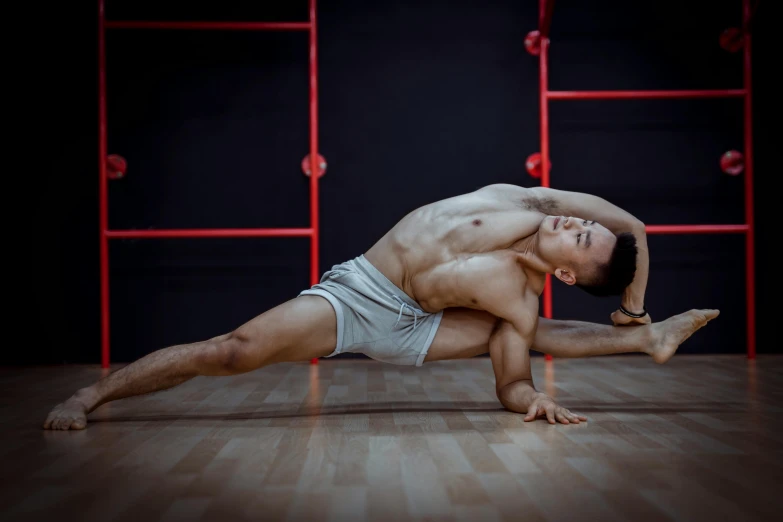 a man doing a yoga pose on a wooden floor, a portrait, unsplash, arabesque, gogo dancer, asian male, professional photo-n 3, studio photo