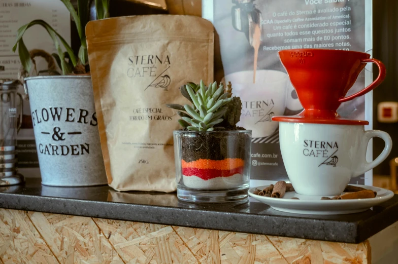 a couple of cups sitting on top of a counter, by Stefan Gierowski, pexels contest winner, verdadism, green and red plants, celebration of coffee products, layers of strata, jar on a shelf