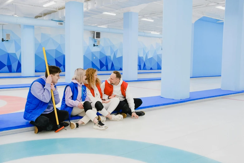 a group of people sitting on top of a curling rink, profile image, dominant wihte and blue colours, scandinavian, white floor