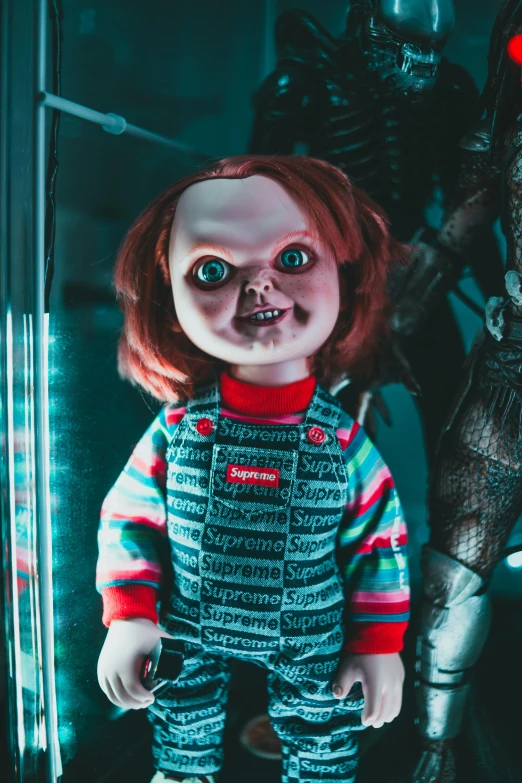 a close up of a doll with a creepy face, a hologram, inspired by Guillermo del Toro, trending on pexels, chucky, red and black robotic parts, superhero from the boys tv show, a still of a happy