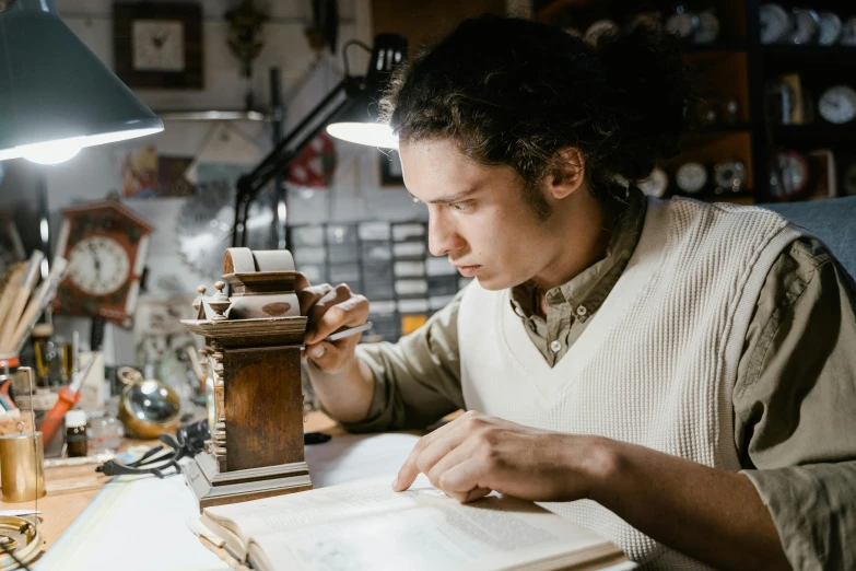 a man sitting at a table reading a book, pexels contest winner, arts and crafts movement, microscopy, inspect in inventory image, weta workshop, henry ascensio