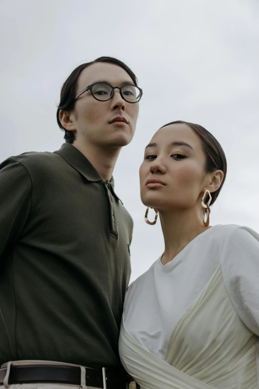 a man and a woman standing next to each other, inspired by Wang Duo, trending on unsplash, aestheticism, wearing square glasses, high collar, federation clothing, fashion model features