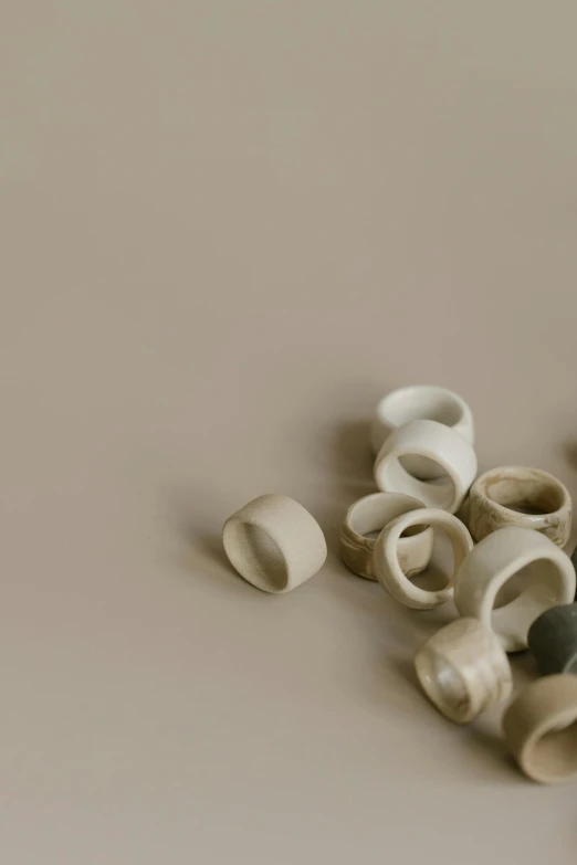 a pile of toothbrushes sitting on top of a table, a marble sculpture, by Rebecca Horn, unsplash, minimalism, runic rings, beige colors, made out of clay, wood cups