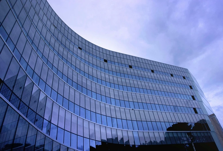 a very tall building with a lot of windows, a picture, inspired by Tadao Ando, flickr, woamn is curved, photo of zurich, office, cinematic view from lower angle