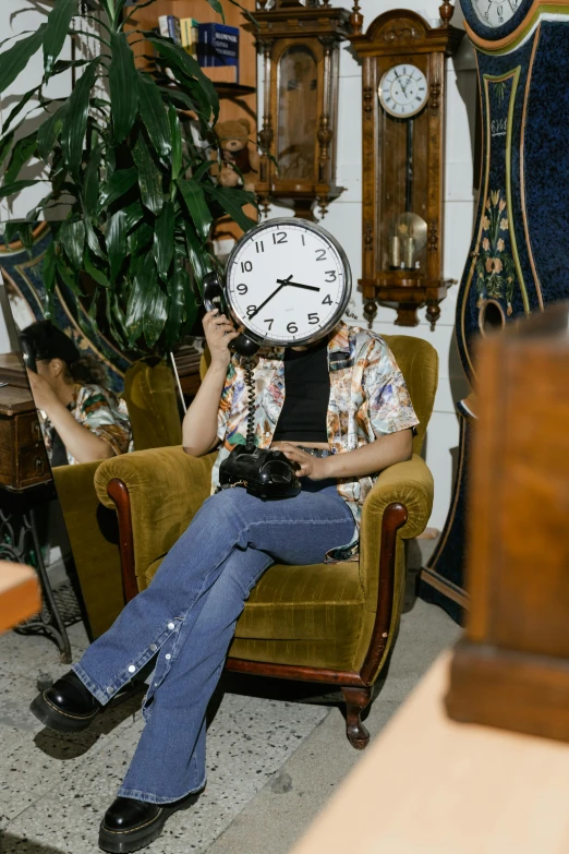 a man sitting in a chair with a clock on his head, by Everett Warner, trending on pexels, maximalism, office/thrift store/social hall, checking her phone, inspect in inventory image, sydney hanson