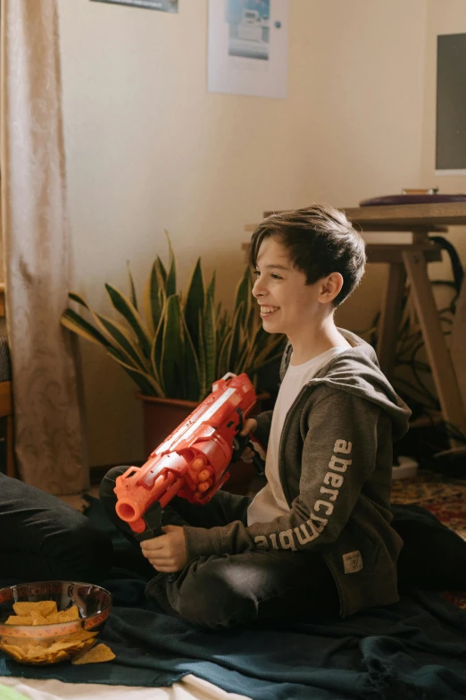 a couple of people that are sitting on the floor, holding a blaster, teen boy, wholesome, gen z