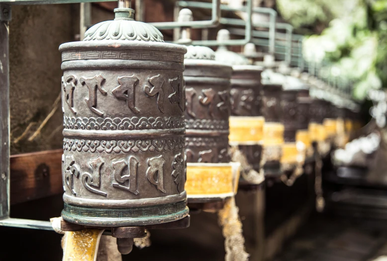 a group of bells hanging from the side of a building, an album cover, trending on unsplash, cloisonnism, tibetan text script, avatar image, in a monestry natural lighting, thumbnail