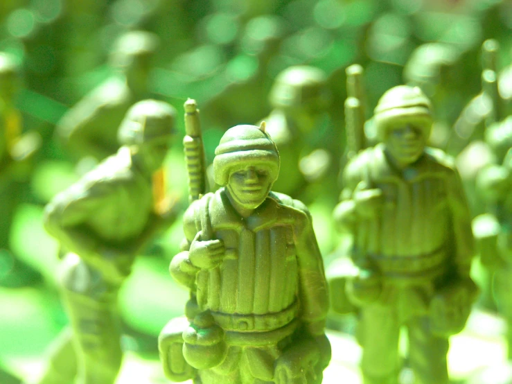 a close up of a group of figurines of baseball players, by Adam Marczyński, unsplash, plasticien, military gear, full of greenish liquid, vietnam war soldier, monochromatic green