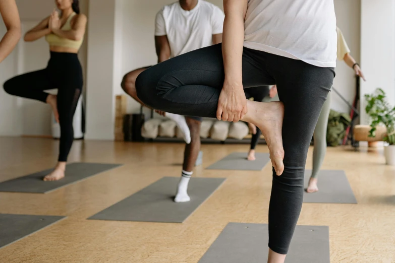 a group of people doing yoga in a room, trending on pexels, arabesque, thighs focus, thumbnail, hand on hip, manuka