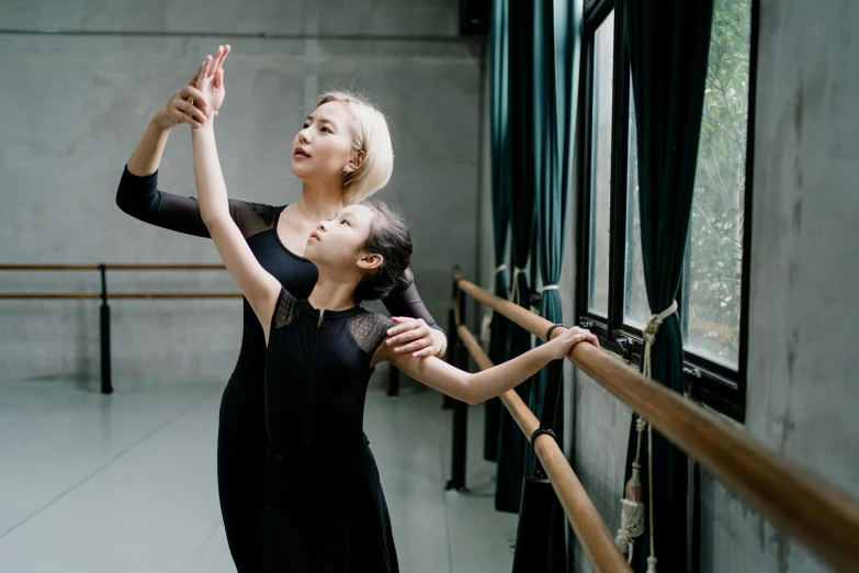 a woman in a black dress and a little girl in a black dress, inspired by Fei Danxu, pexels contest winner, arabesque, teaching, thumbnail, side pose, square