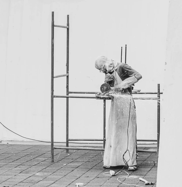a black and white photo of a man working on scaffolding, a statue, by Jan Rustem, old woman, performance art, with a wooden stuff, post+processing