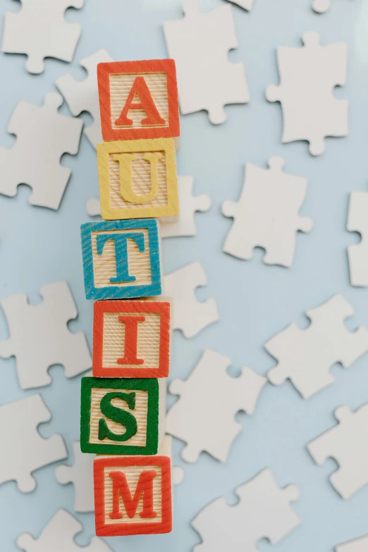 a pile of puzzle pieces with the word autism spelled on them, by Harriet Zeitlin, as seen on getty images, jen atkin, rays, 1 6 x 1 6