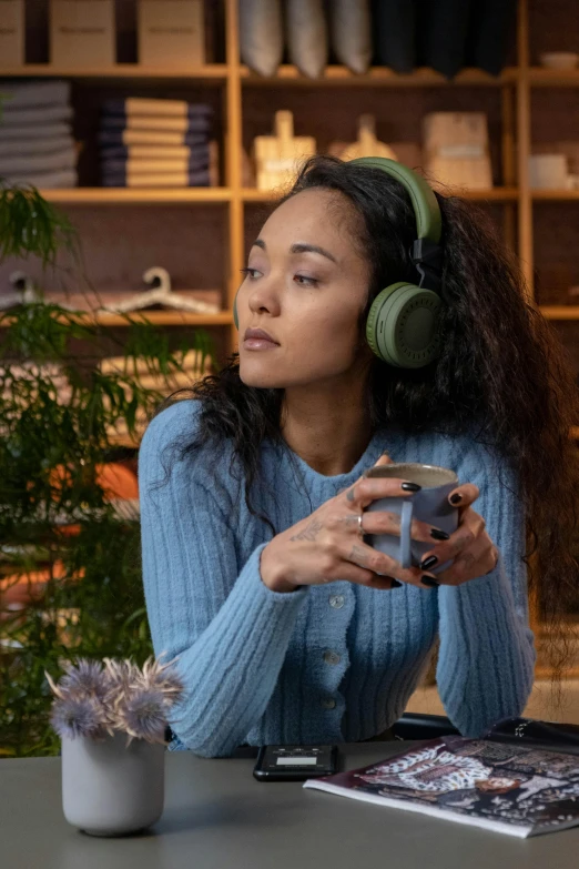 a woman sitting at a table with headphones on, trending on pexels, renaissance, wearing a green sweater, sitting on a store shelf, netflix, bang olufsen