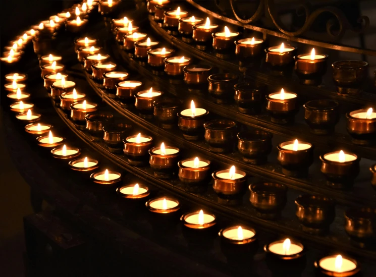 a row of lit candles sitting on top of a table