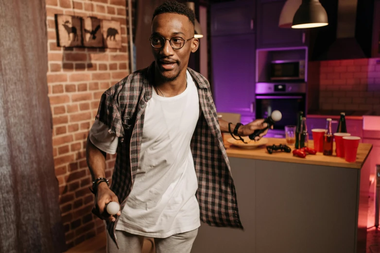 a man standing in a kitchen next to a counter, inspired by Ismail Gulgee, pexels contest winner, holding a light saber, man with glasses, handsome hip hop young black man, halloween