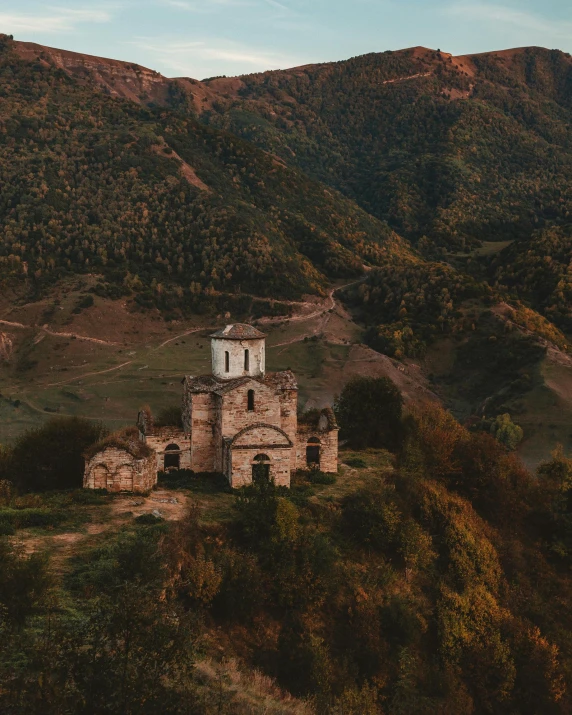 an old building sitting on top of a hill, by Emma Andijewska, pexels contest winner, renaissance, orthodox christianity, in a valley, during autumn, early evening