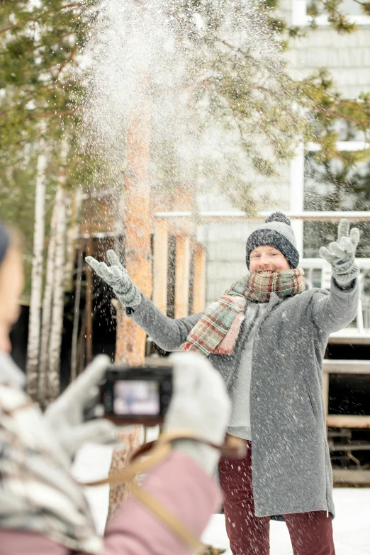 a woman is throwing snow in the air, by Eero Järnefelt, pexels contest winner, selfie of a man, meet the actor behind the scenes, home video footage, grey