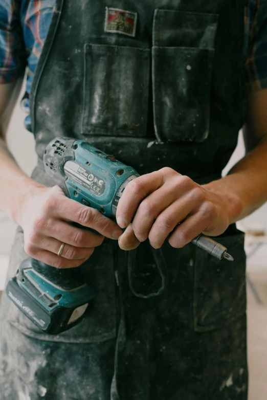 a close up of a person holding a drill, pexels contest winner, arbeitsrat für kunst, teal aesthetic, full body hero, carpenter, a man wearing a black jacket