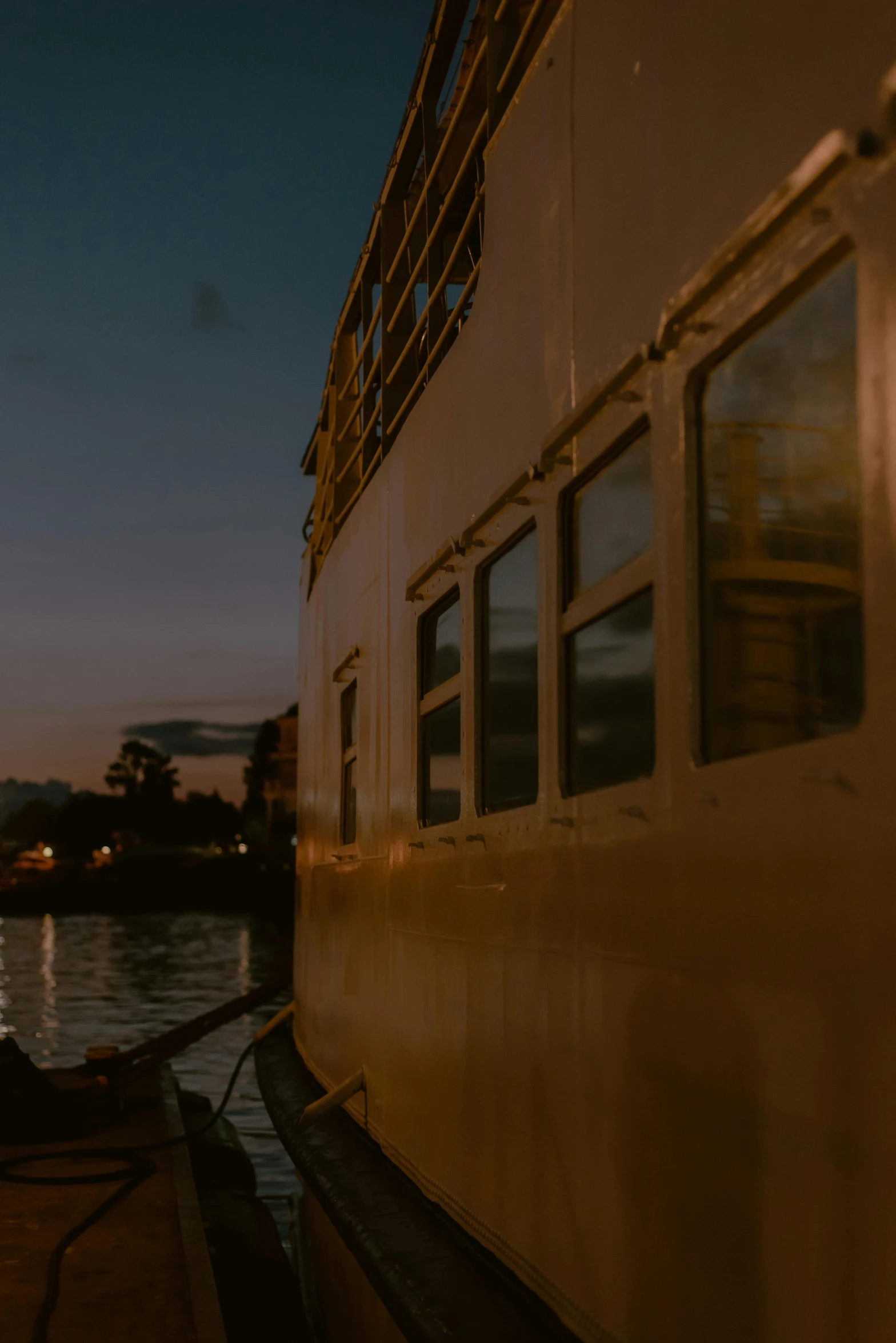 a boat sitting on top of a body of water, unsplash, modernism, night time footage, on the deck of a ship, profile shot, yellow