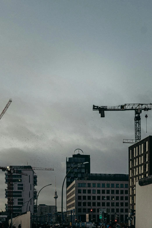 a street filled with lots of traffic next to tall buildings, by Tobias Stimmer, pexels contest winner, constructivism, sitting in a crane, reykjavik, under construction, gray skies