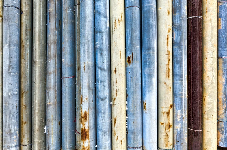 a bunch of pipes sitting next to each other, an album cover, unsplash, plasticien, bamboo, blue gray, hyperdetailed texture, multicolored