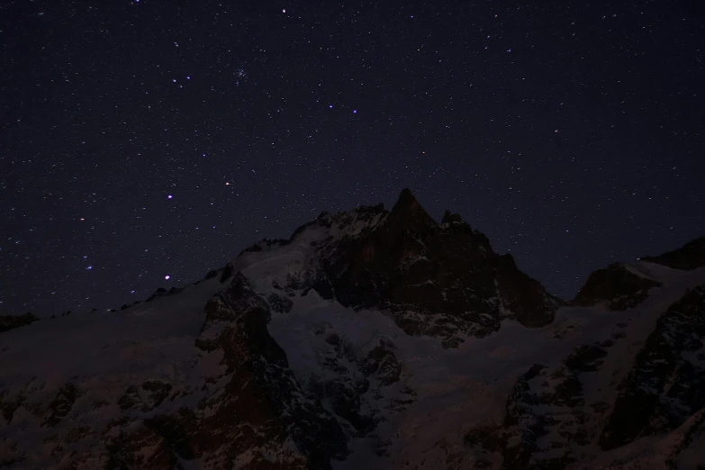 a group of people standing on top of a snow covered mountain, by Peter Churcher, pexels contest winner, digital art, black background with stars, chamonix, middle close up composition, night photo