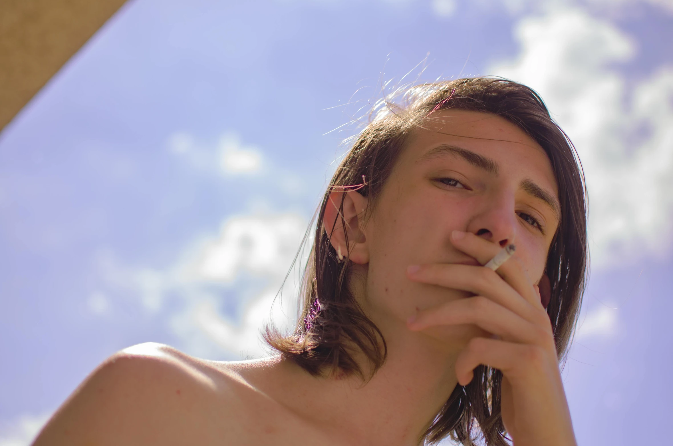 a shirtless young man smokes a cigarette, an album cover, inspired by Elsa Bleda, trending on pexels, cloudless sky, portrait androgynous girl, 1 7 - year - old boy thin face, colored photo