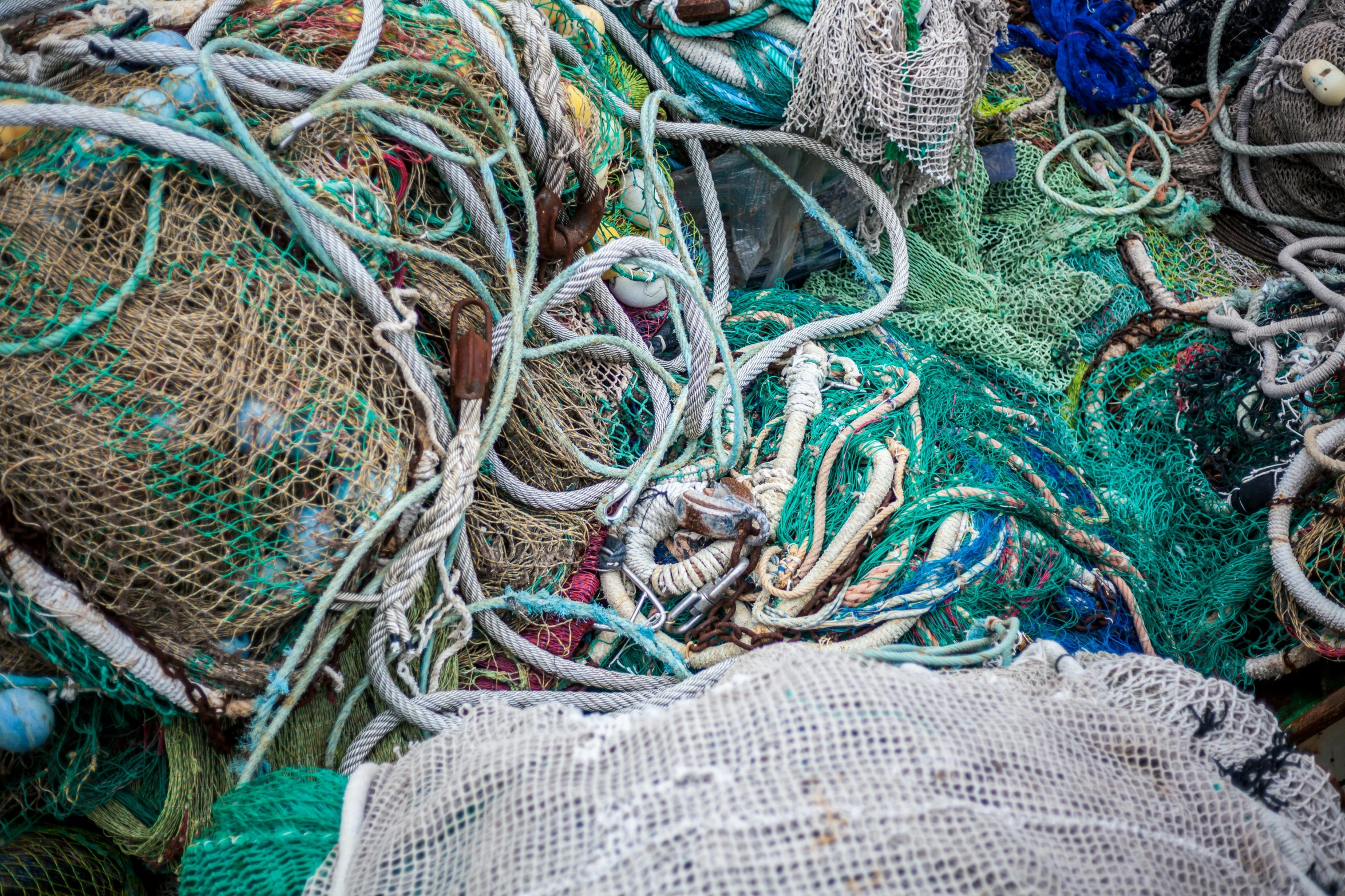 a pile of fishing nets piled on top of each other, by Matija Jama, pexels, plasticien, made of trash, blue and green colours, charts, amanda lilleston