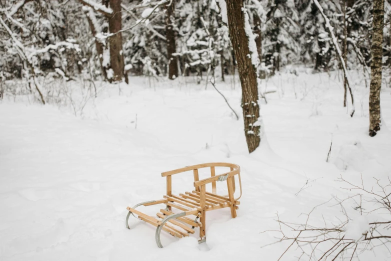 a wooden bench sitting in the middle of a snow covered forest, by Jaakko Mattila, pexels contest winner, land art, with furniture overturned, eva elfie, helsinki, marc newson