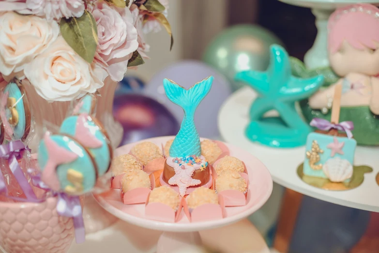 a close up of a plate of food on a table, a cartoon, by Julia Pishtar, unsplash, magical realism, pink glitter mermaid gown, cakes, cyan and gold scheme, at a birthday party