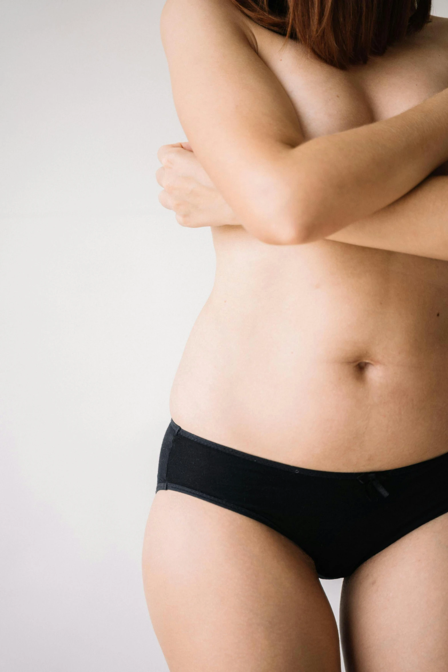 a woman in a black underwear posing for a picture, a digital rendering, unsplash, her belly button is exposed, plain background, taken in the late 2010s, bottom body close up