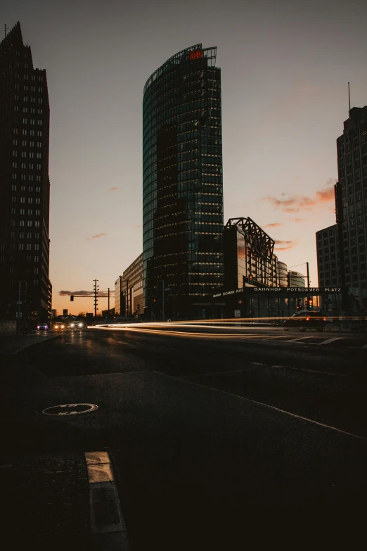 a couple of tall buildings sitting next to each other, by Sebastian Spreng, city street at dusk, driving through the city, high quality image”