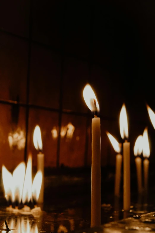 a group of lit candles sitting on top of a table, profile image, digital image