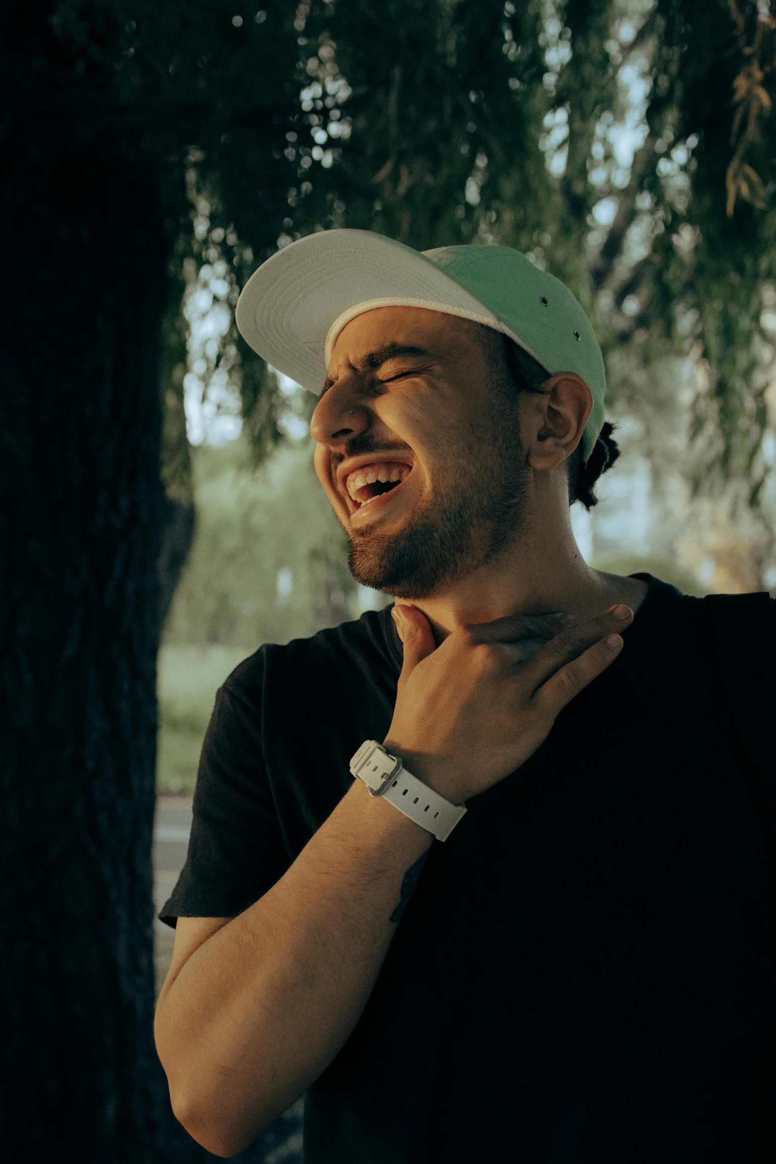 a man standing next to a tree with his hand on his chest, inspired by Alexis Grimou, pexels contest winner, graffiti, happy with his mouth open, mac miller, headshot profile picture, twitch emote