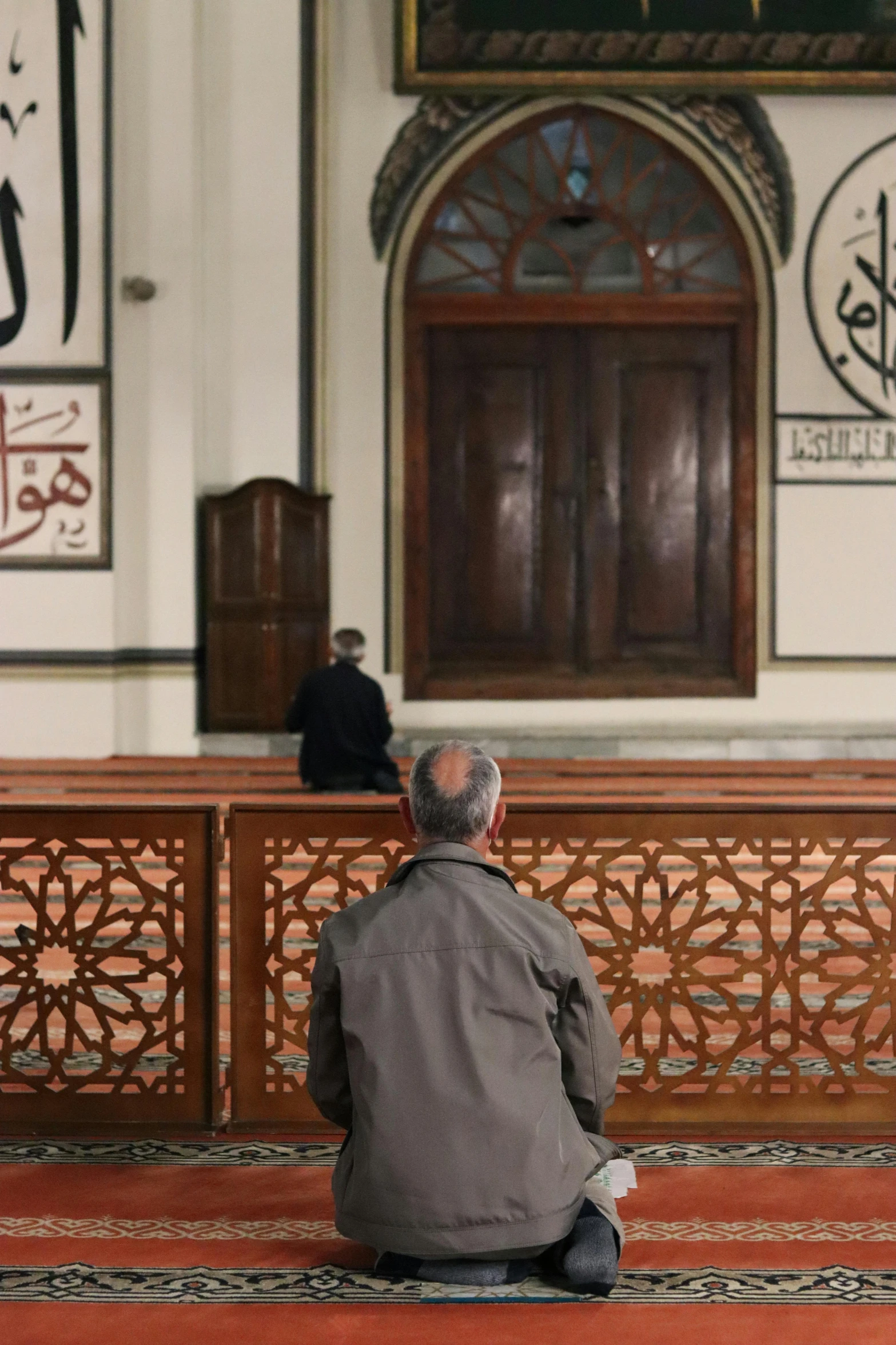 a man sitting on the floor in a mosque, man sitting facing away, man standing, photograph credit: ap, cairo