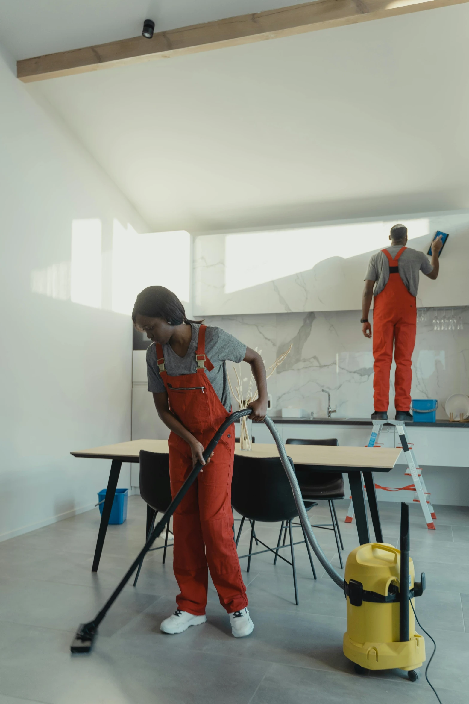 two men are cleaning a room with a vacuum, a colorized photo, pexels contest winner, hyperrealism, instagram story, clean 4 k, men and women, standing on a desk