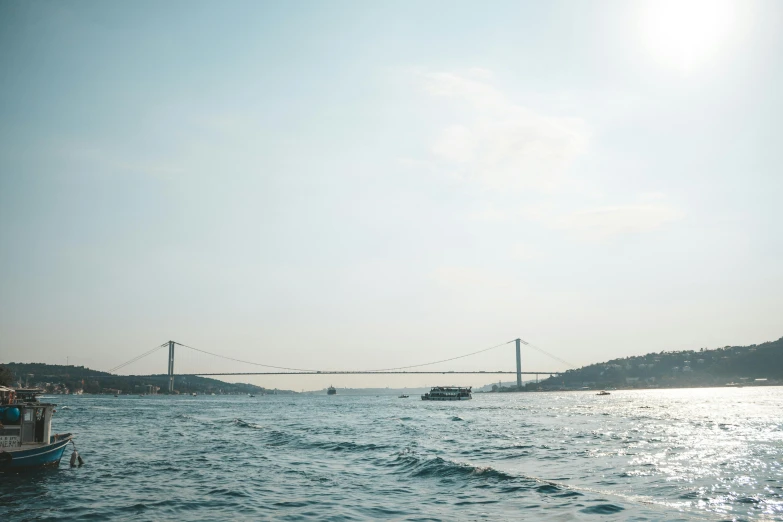 a large body of water with a bridge in the background, pexels contest winner, hurufiyya, istanbul, slight haze, shot on hasselblad, perfect crisp sunlight