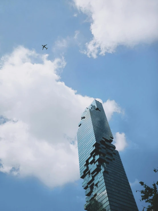 a plane flying in front of a tall building, inspired by Leandro Erlich, pexels contest winner, mexico city, low quality photo, morphosis, bird\'s eye view