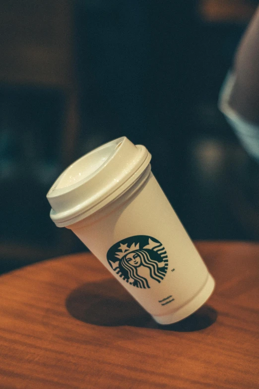 a starbucks cup sitting on top of a wooden table, detailed product image, detail shot, multiple stories, small in size