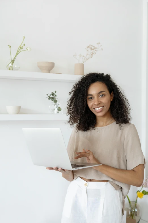 a woman standing in a kitchen holding a laptop, pexels contest winner, renaissance, curls on top, white background, african american young woman, it specialist