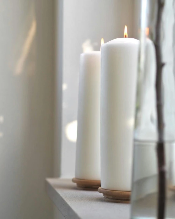 three white candles sitting on top of a window sill, inspired by Okada Hanko, oak, very large, church, soft white rubber