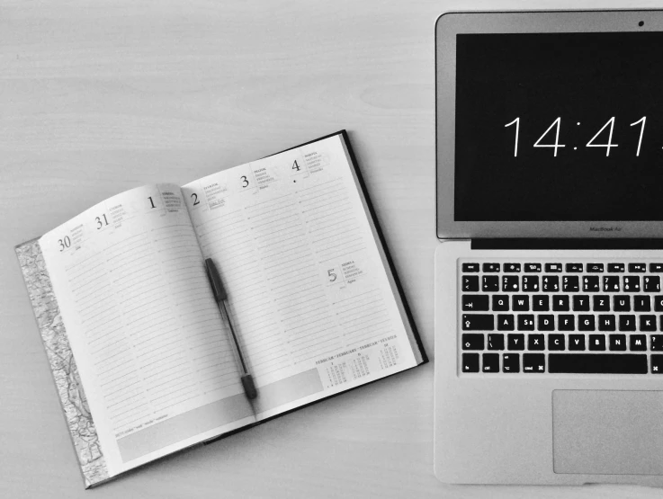 a laptop computer sitting on top of a wooden desk, a black and white photo, pixabay, clock, writing in journal, flat lay, screenshots