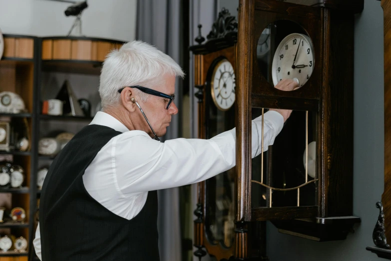 a man that is standing in front of a clock, pexels contest winner, arts and crafts movement, man with glasses, inspect in inventory image, a silver haired mad, tinnitus