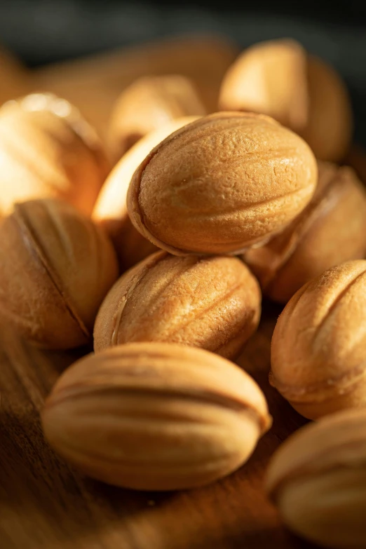 a pile of almonds sitting on top of a wooden cutting board, by Harold von Schmidt, renaissance, up-close, intricate wrinkles, sun setting, zoomed in