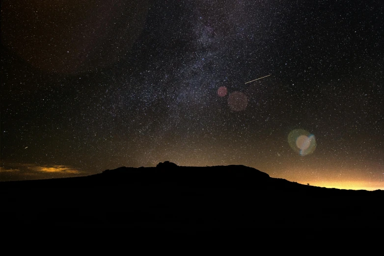 a sky filled with lots of stars next to a mountain, shining meteor, small spacecraft in background, black, brown