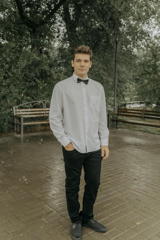 a man in a bow tie standing in a park, an album cover, inspired by Kristian Kreković, pexels contest winner, casual clothes, magnus carlsen, overcast mood, square masculine jaw