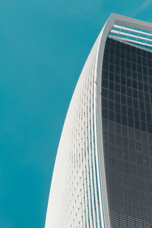 a tall building with a blue sky in the background, inspired by Zaha Hadid, pexels contest winner, gambrel roof, boston, a pair of ribbed, white sweeping arches