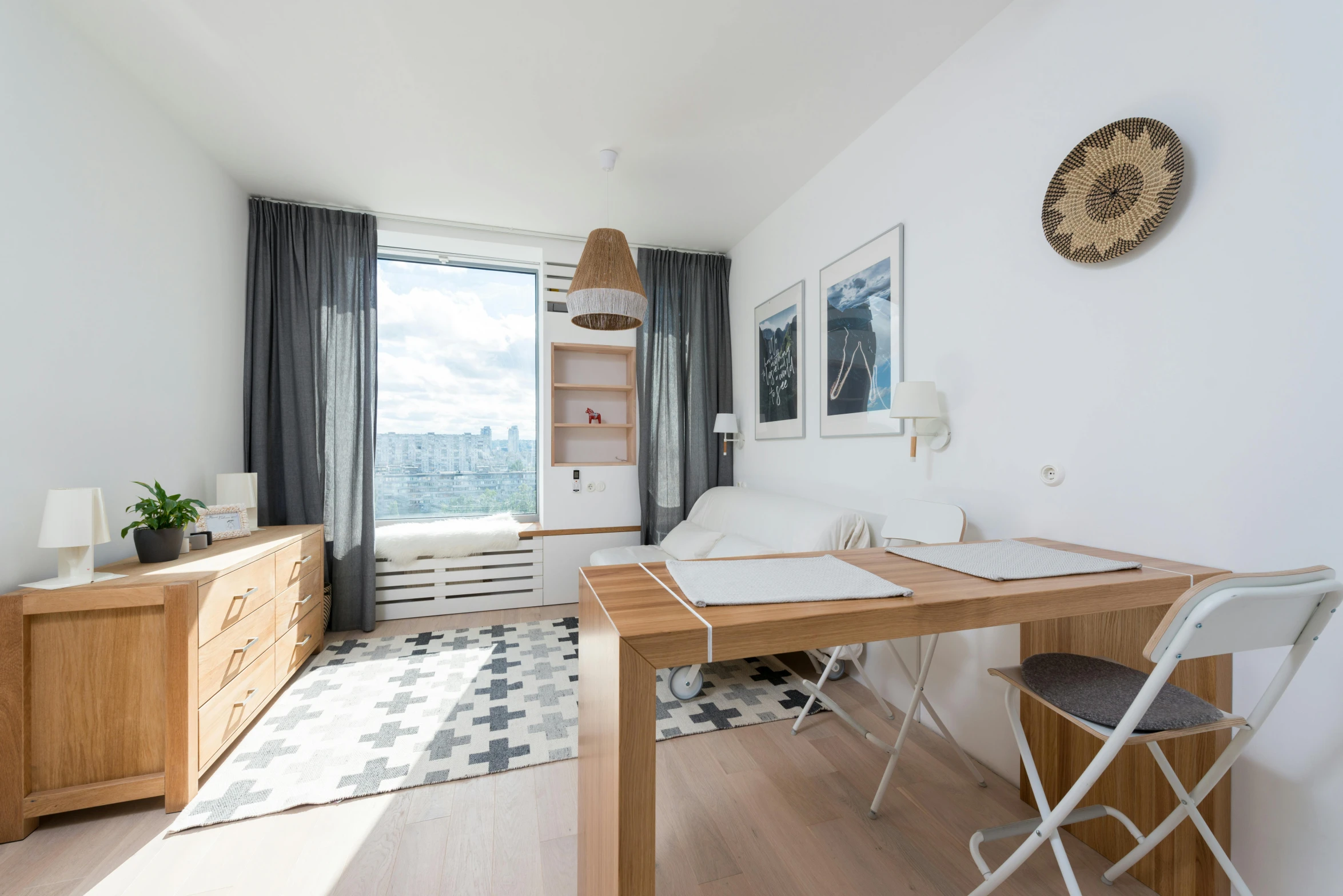 a living room filled with furniture and a wooden table, by Adam Marczyński, unsplash, light and space, small and cosy student bedroom, overlooking a modern city, neo kyiv, seaview