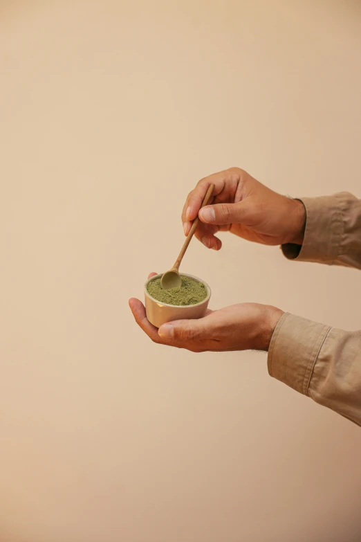 a person holding a bowl with a spoon in it, green tea, detailed product image, koji morimoto, medium-shot