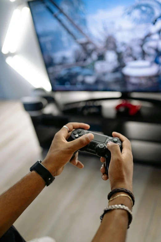 a person holding a video game controller in front of a tv, thumbnail, electronics, educational, connectivity
